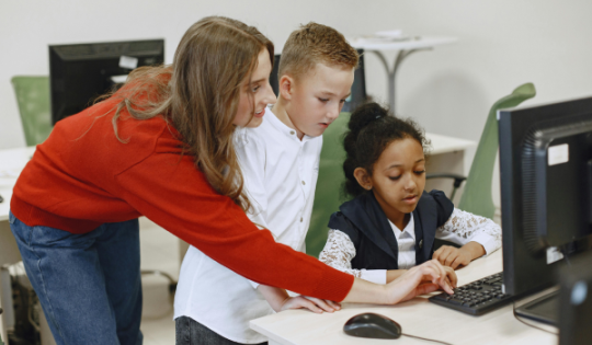 kids and teacher using computer