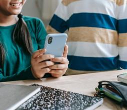 Two children looking at a mobile phone